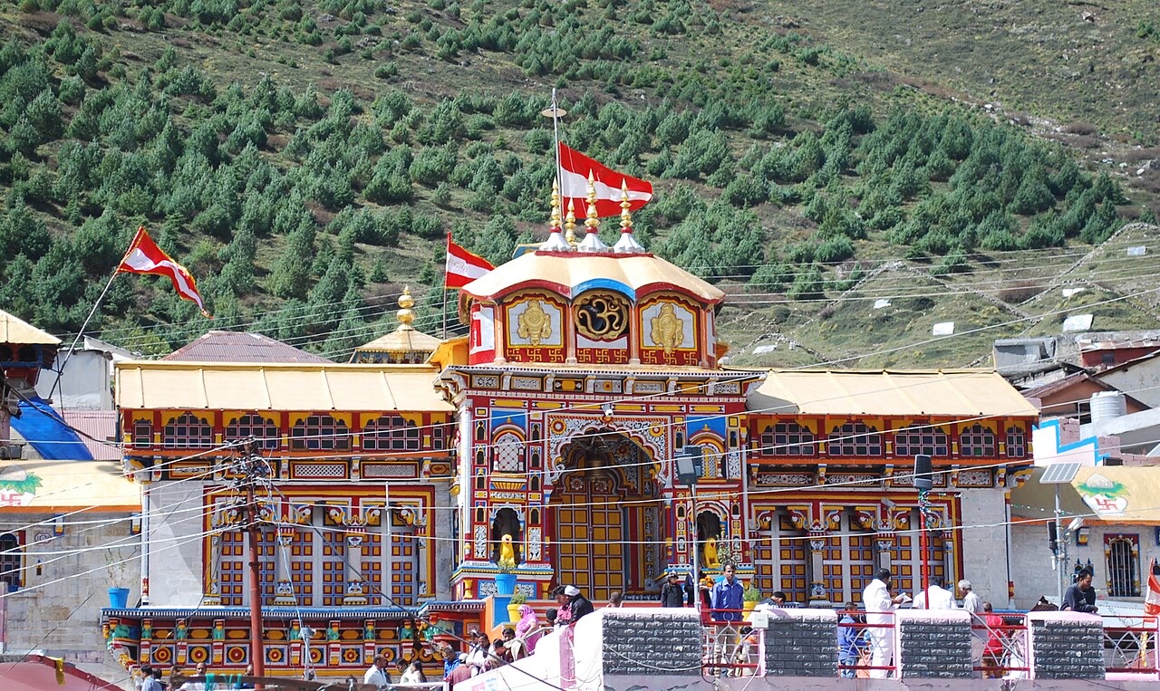 The painted facade of Badrinath temple with flags flying in front