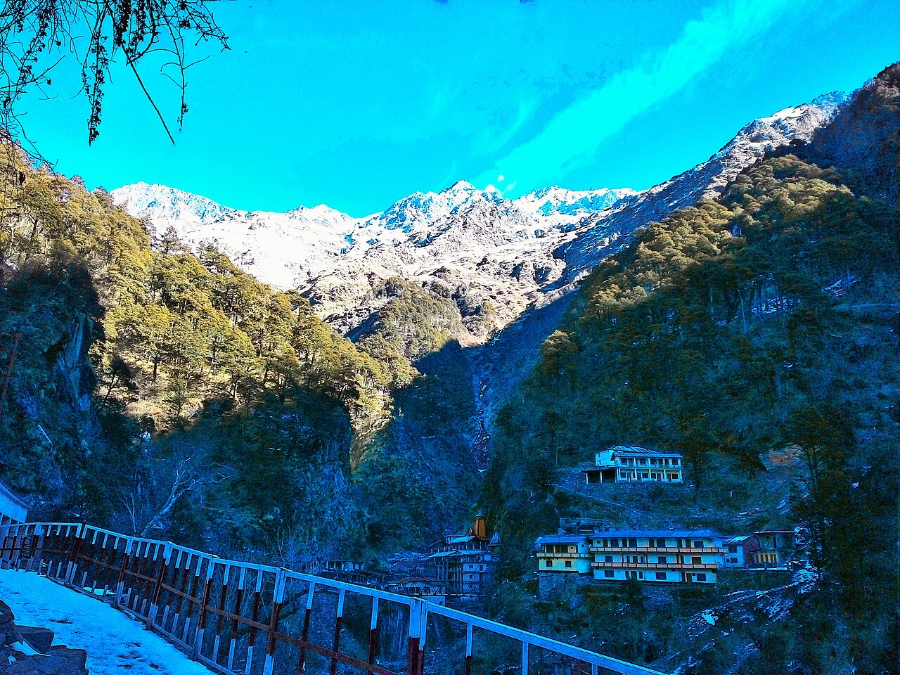 Yamunotri temple in a deep valley below snowy Himalayan peaks