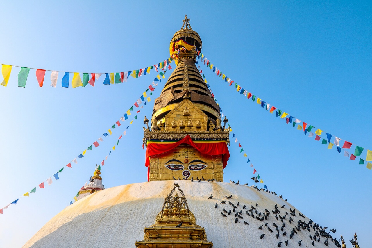 The gilded spire and painted eyes of Swayambhunath stupa in Kathmandu with prayer flags