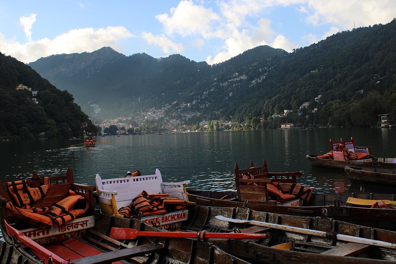 Colourful boats moored on Naini Lake with the hills of Nainital behind