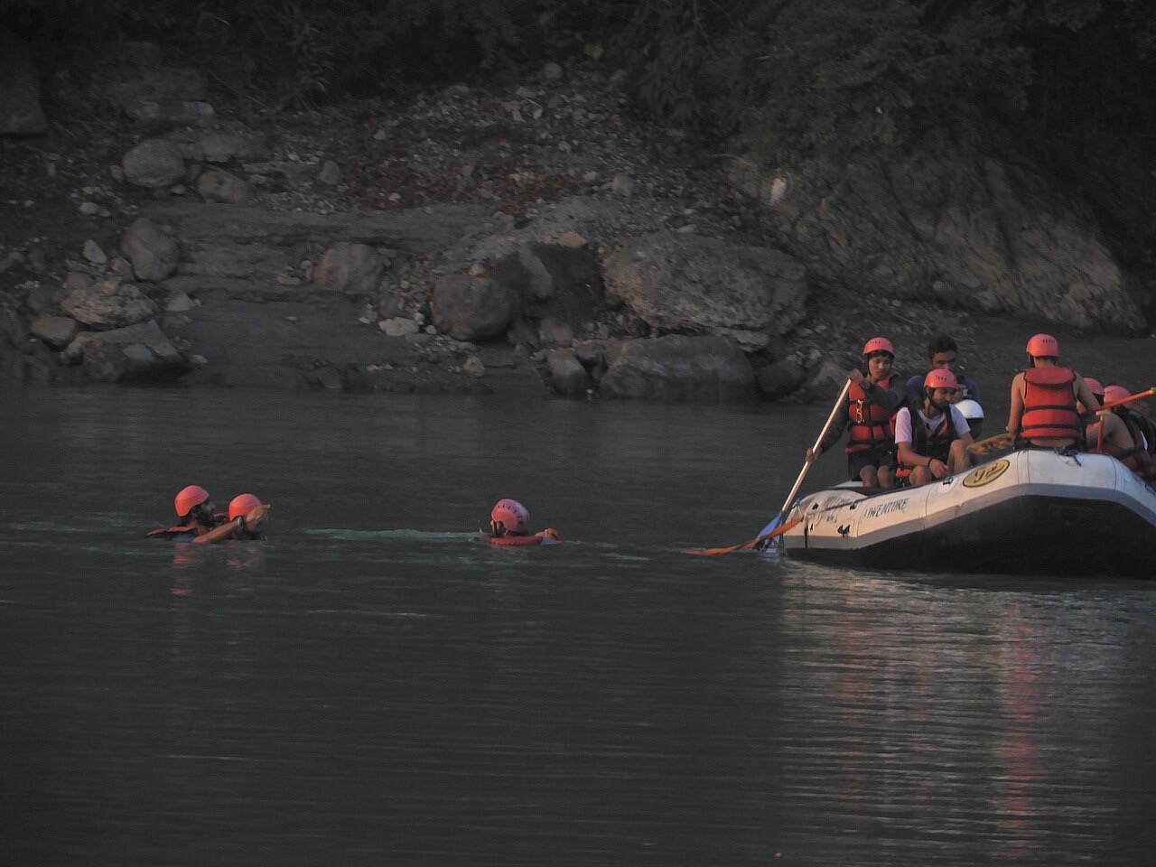A raft of paddlers in helmets on the Ganga near Ram Jhula, Rishikesh